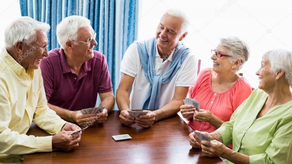 Ältere Menschen die zusammen Karten spielen